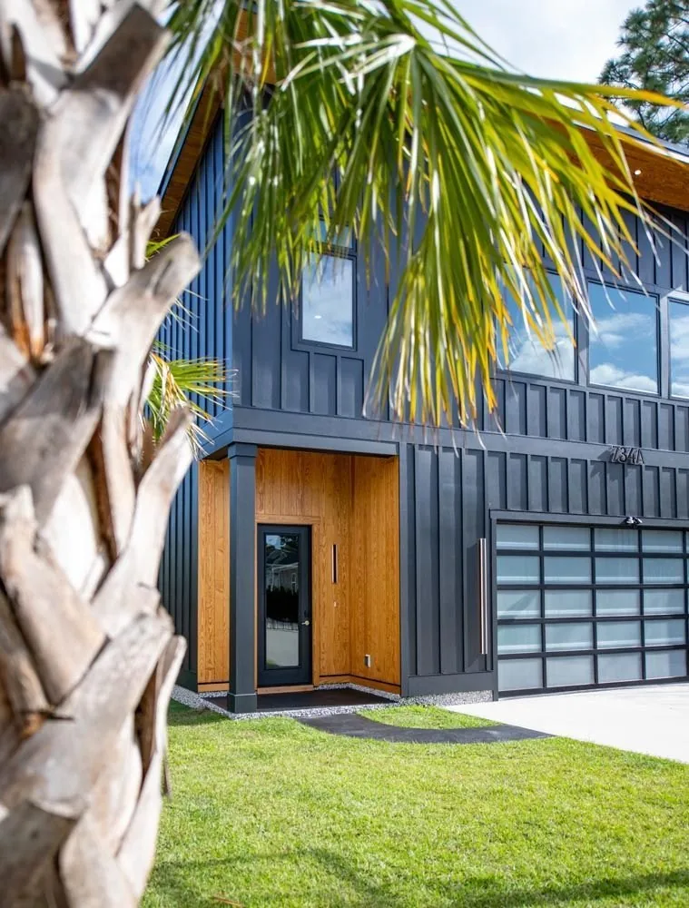 Accessory dwelling unit with dark vertical siding and a wood entry
