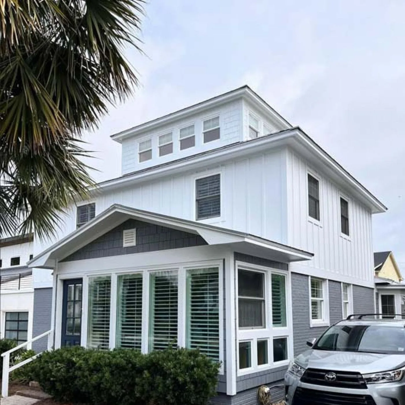 Home exterior with new white siding, black trim and a bay window