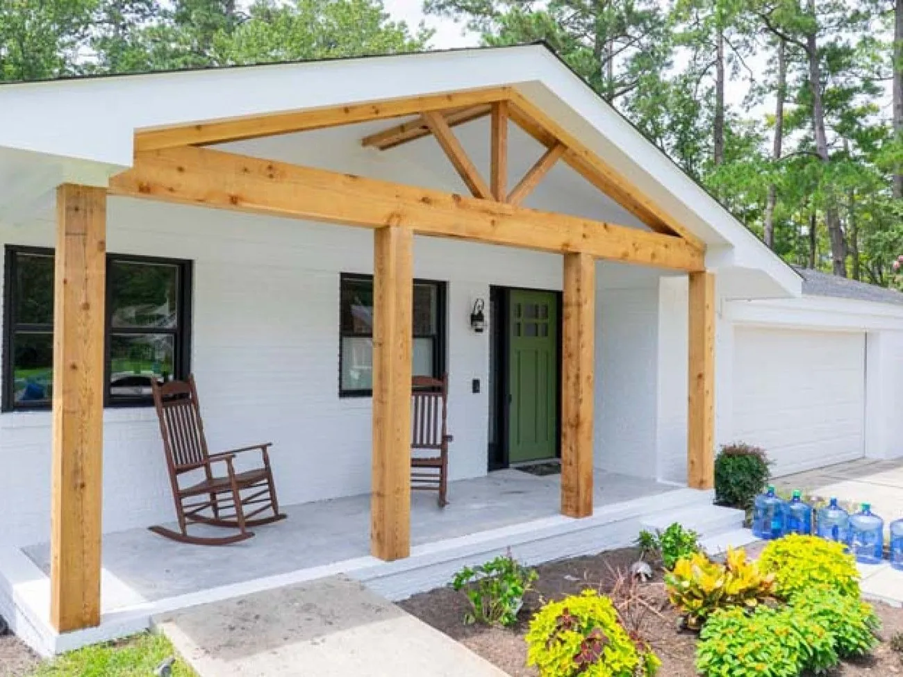 Front porch with heavy timber trusses, rocking chairs and new landscaping
