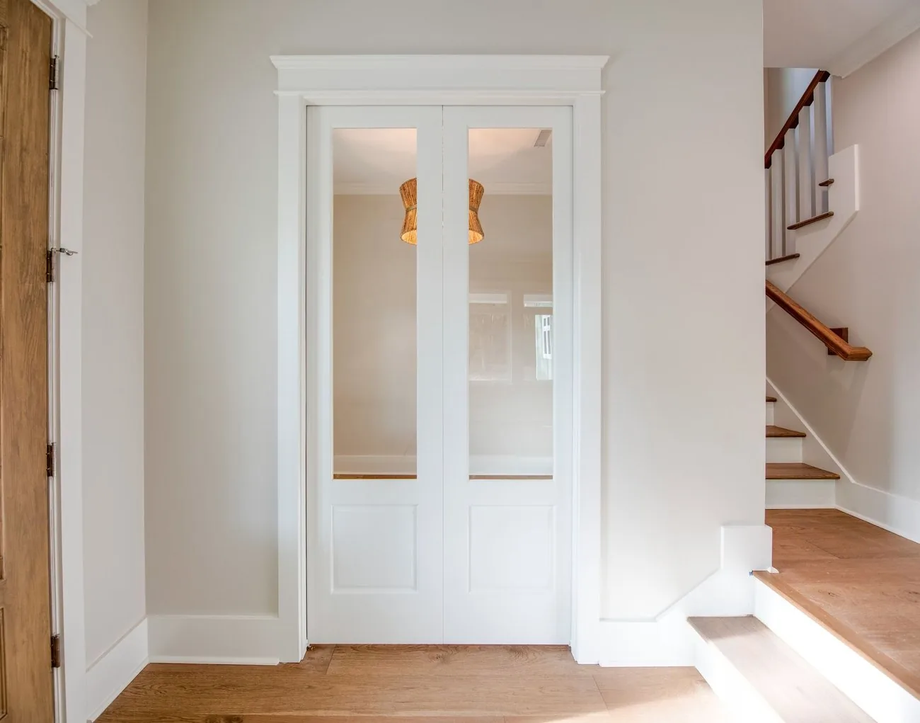 Entry hall with paneled double doors and a staircase
