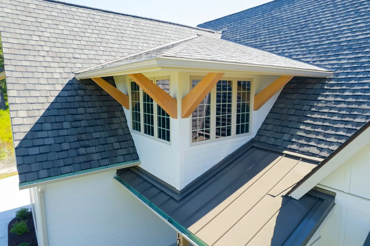 Roof detail with shingles, standing seam metal and timber brackets